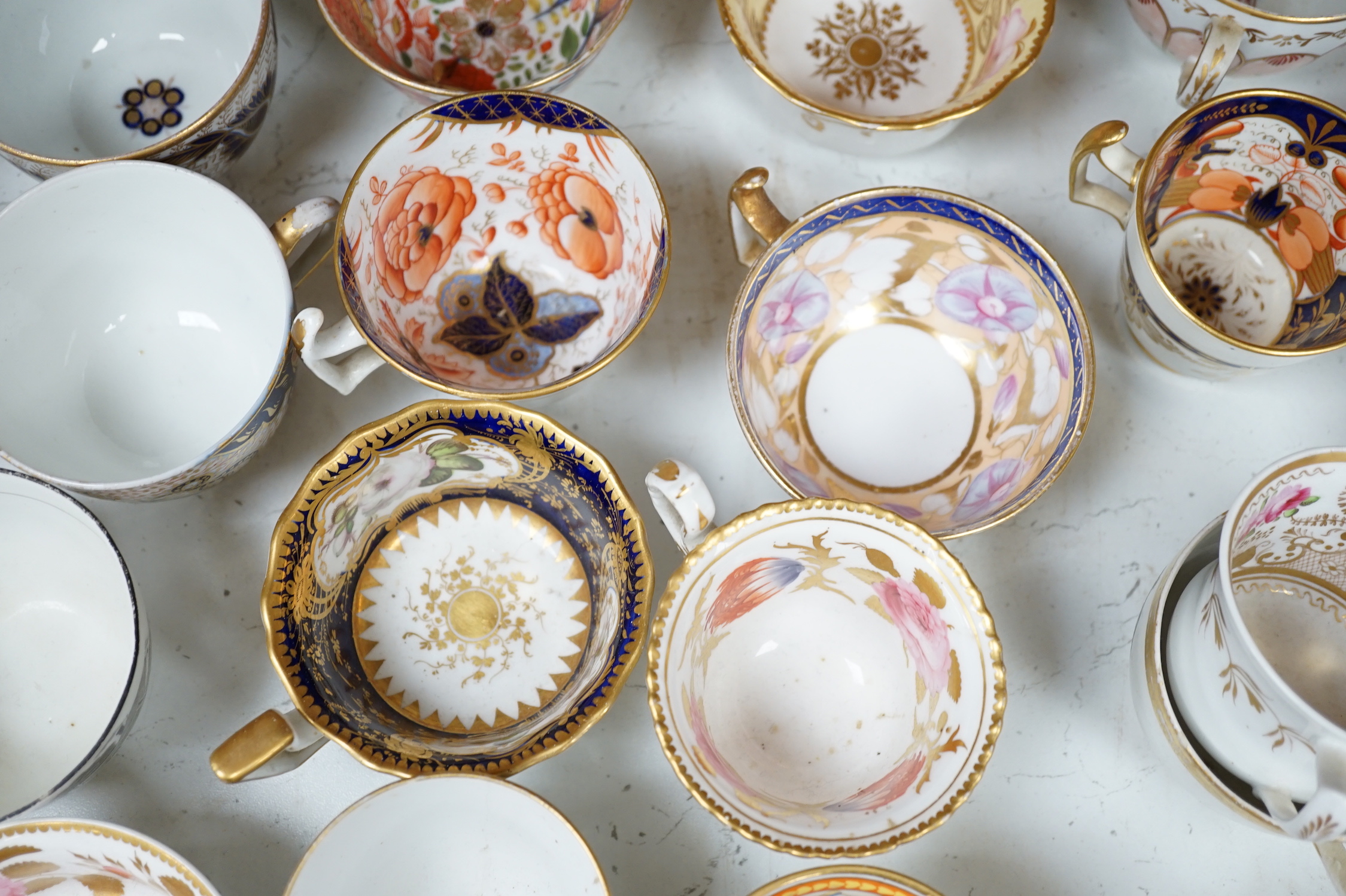 A group of Regency and Victorian porcelain tea, coffee cups and saucers, Newhall, Chamberlains, Coalport, etc.